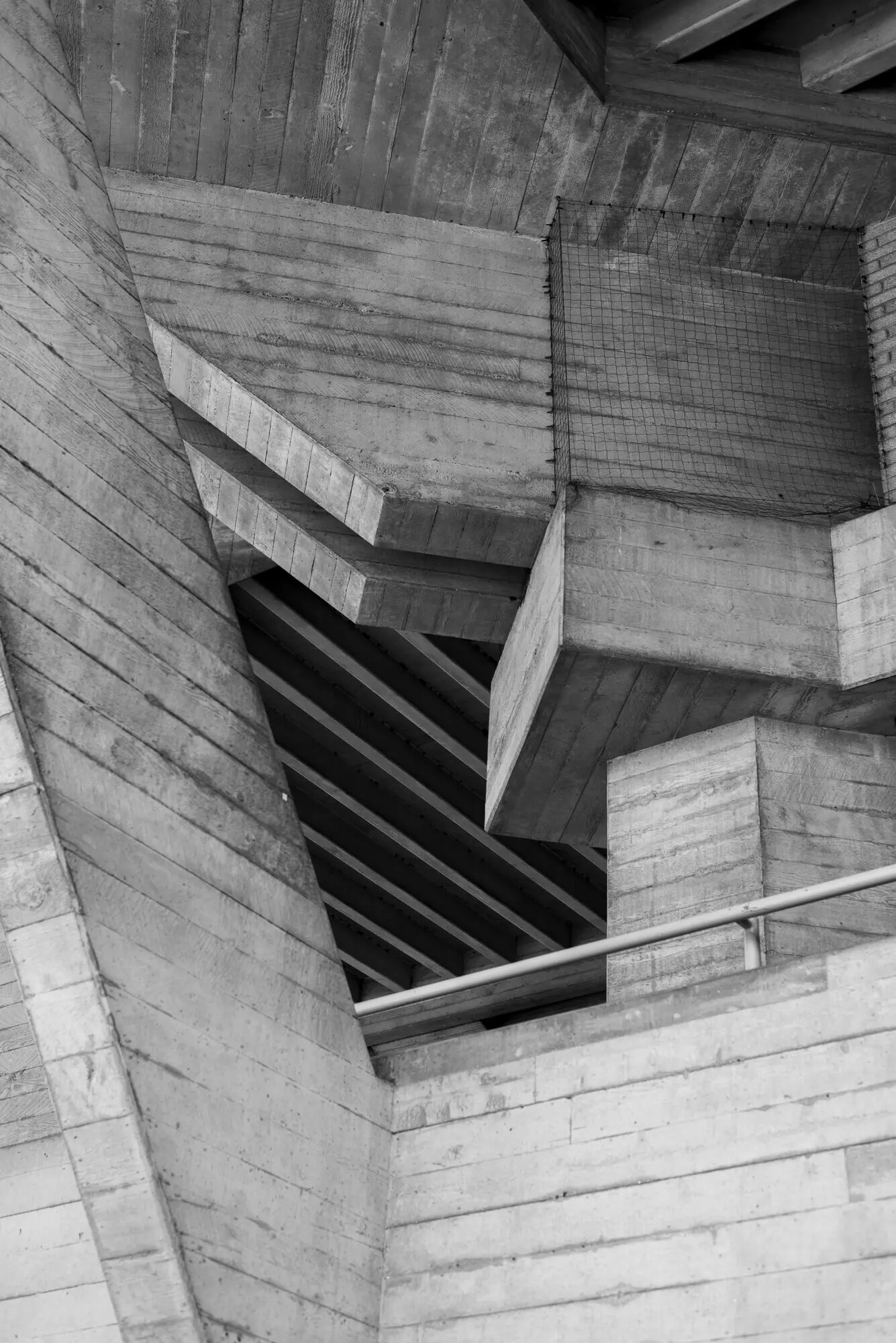 Portrait-oriented greyscale photo of an old attic with a wooden ceiling.